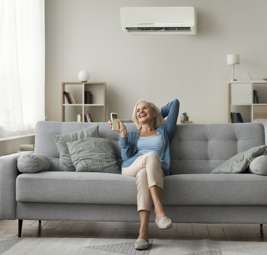 Happy senior holding remote on sofa