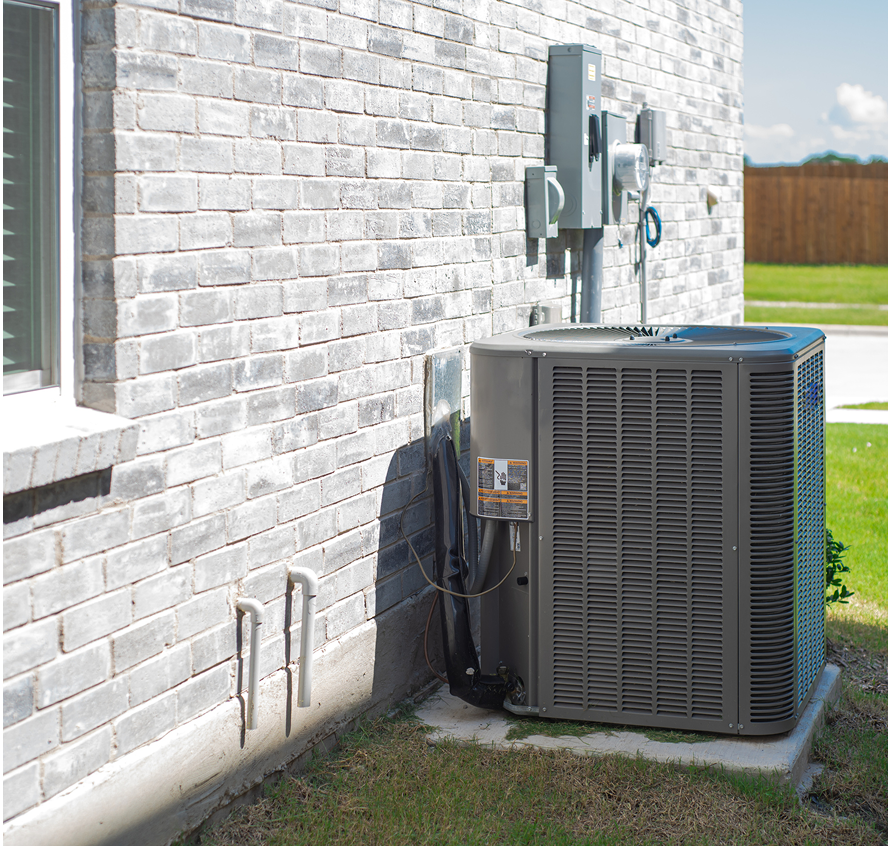 Air conditioning unit beside brick wall