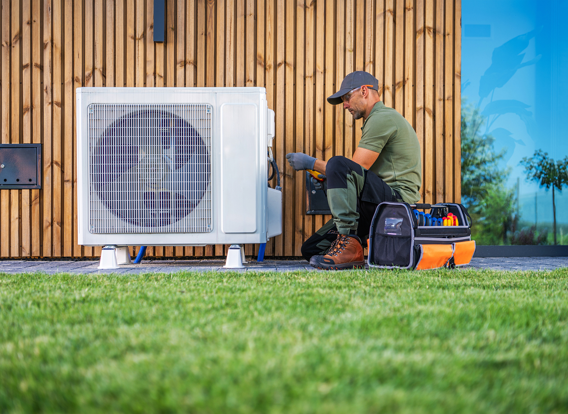 Technician repairing outdoor air conditioning unit