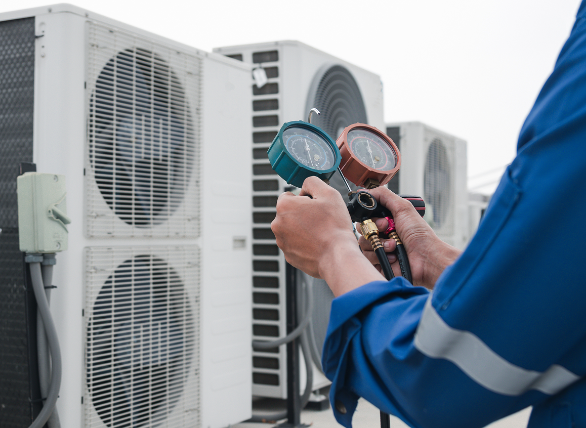 Technician using gauges on HVAC units