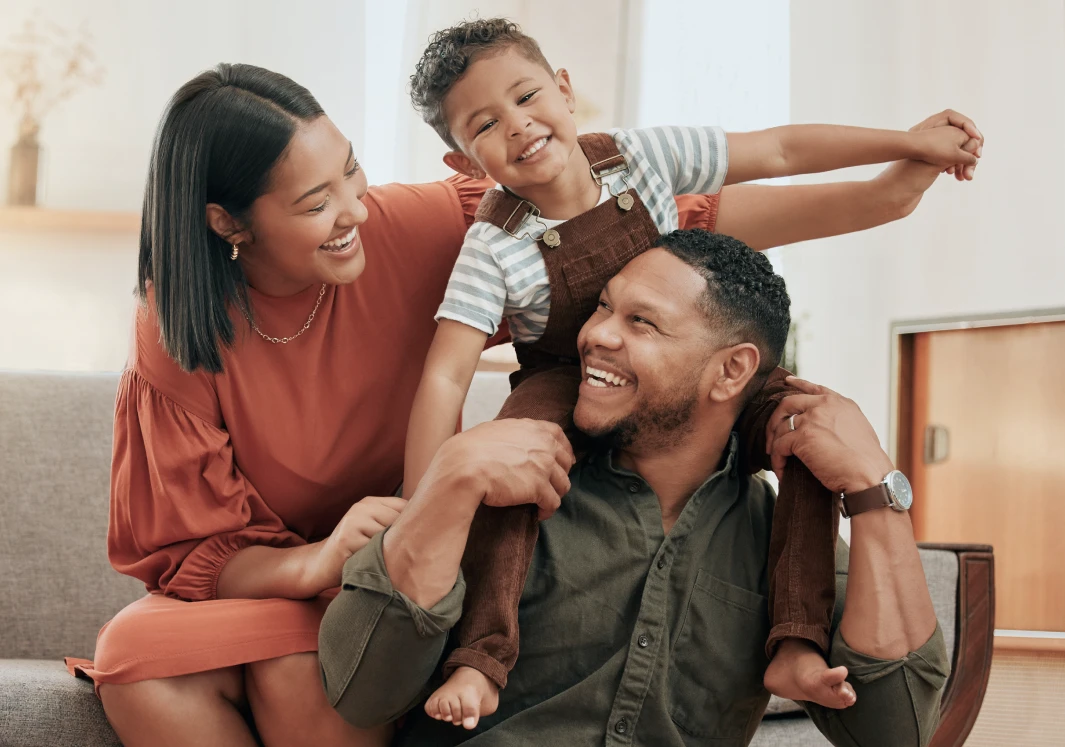 Smiling parents with child on shoulders