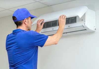 Technician servicing air conditioning unit