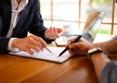 Hands holding pens over contract